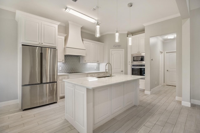 kitchen featuring white cabinets, an island with sink, stainless steel appliances, and custom exhaust hood