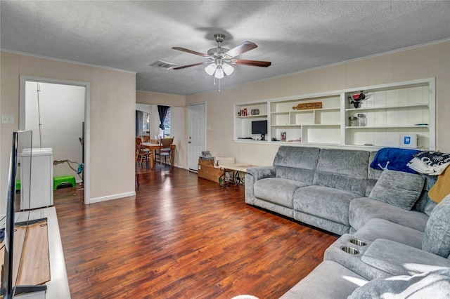 living room featuring dark hardwood / wood-style flooring, ornamental molding, and a textured ceiling