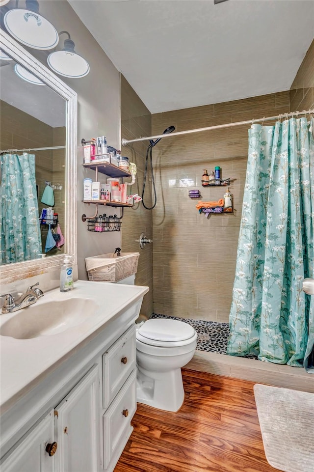 bathroom featuring vanity, hardwood / wood-style floors, a shower with curtain, and toilet