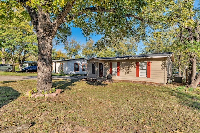 ranch-style house featuring cooling unit and a front lawn