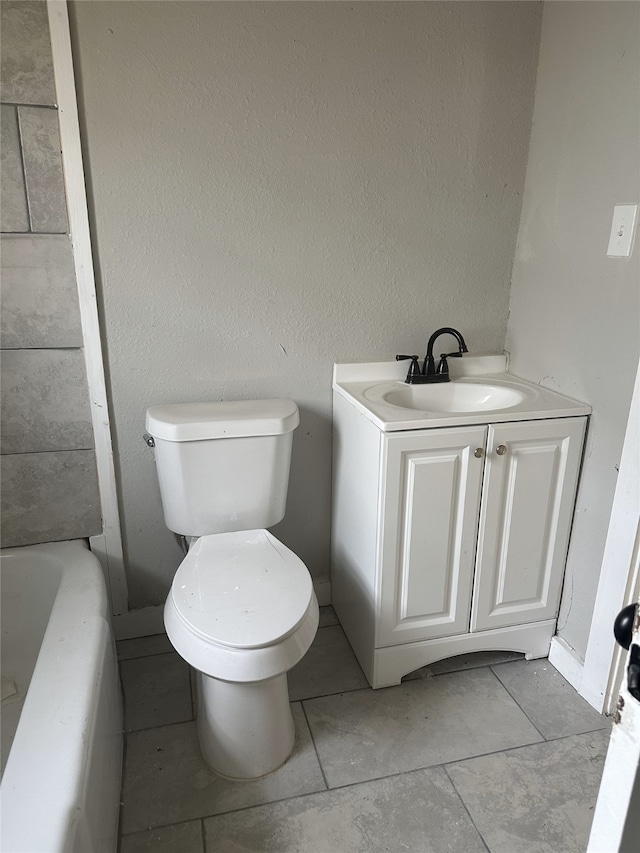 bathroom featuring vanity, toilet, and a tub