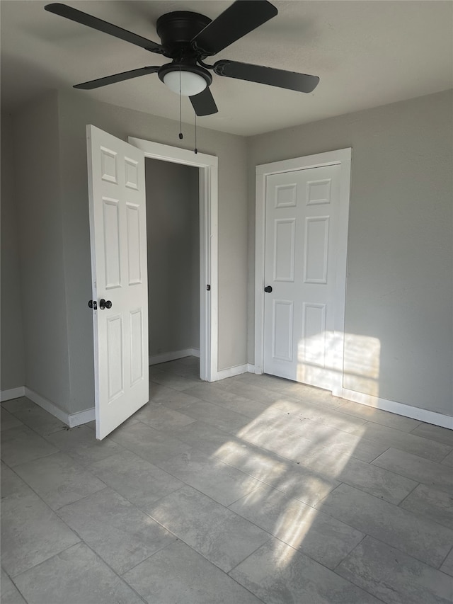 unfurnished bedroom featuring ceiling fan and a closet