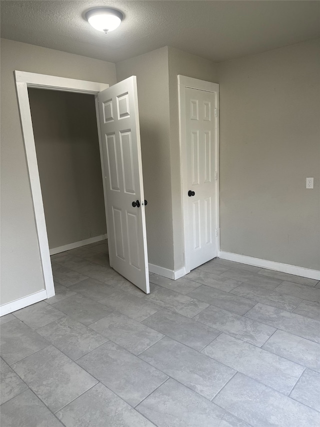 unfurnished room featuring a textured ceiling