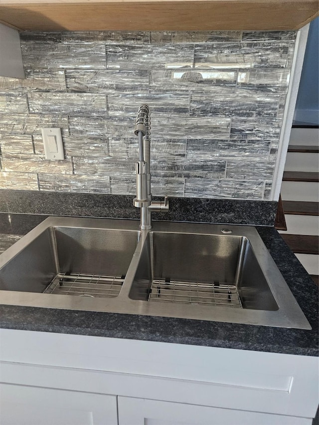 room details with white cabinetry, sink, and tasteful backsplash