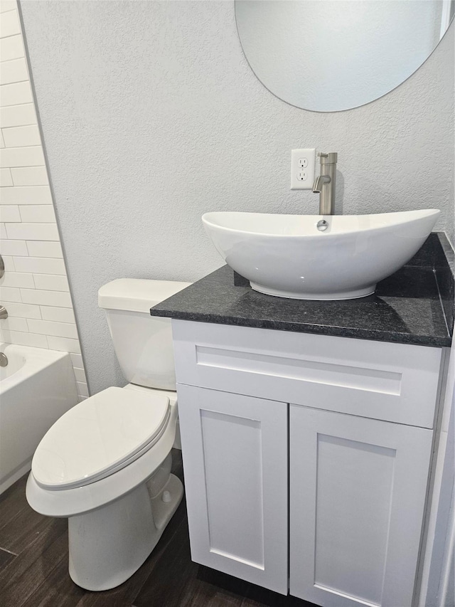 full bathroom with bathtub / shower combination, wood-type flooring, vanity, and toilet