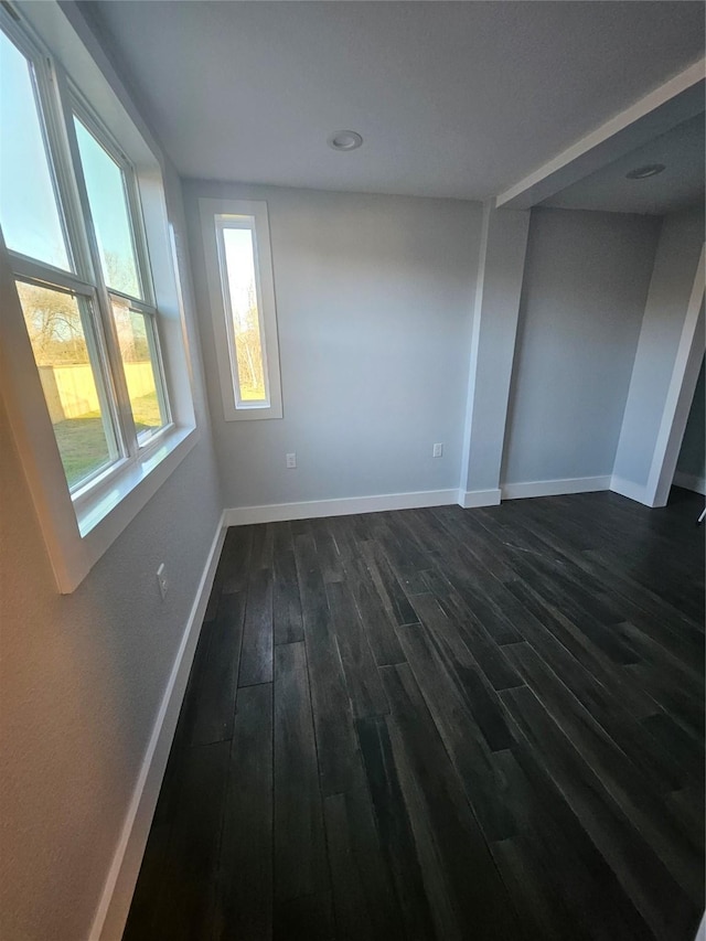 empty room with dark hardwood / wood-style flooring