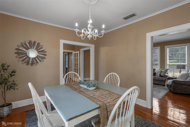 dining room with ornamental molding, dark wood-type flooring, and an inviting chandelier