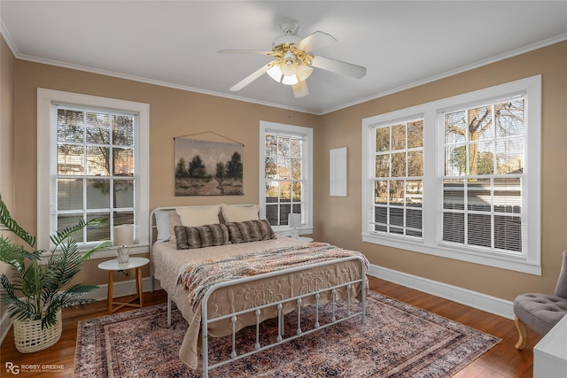 bedroom with hardwood / wood-style flooring, crown molding, and ceiling fan