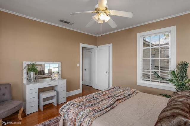 bedroom featuring ceiling fan, ornamental molding, and hardwood / wood-style flooring