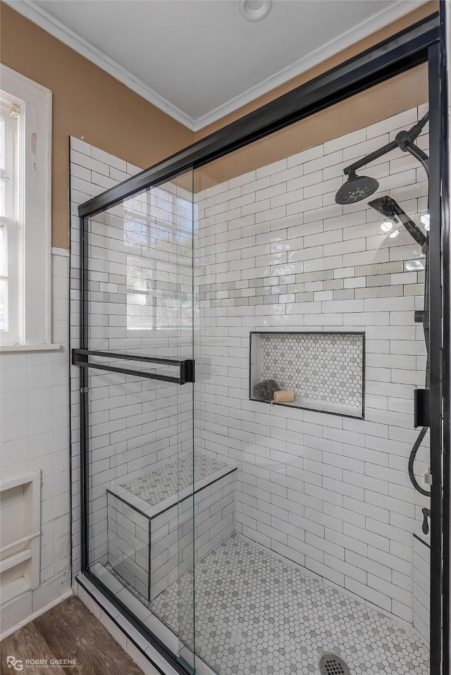 bathroom featuring hardwood / wood-style floors, ornamental molding, and a shower with door