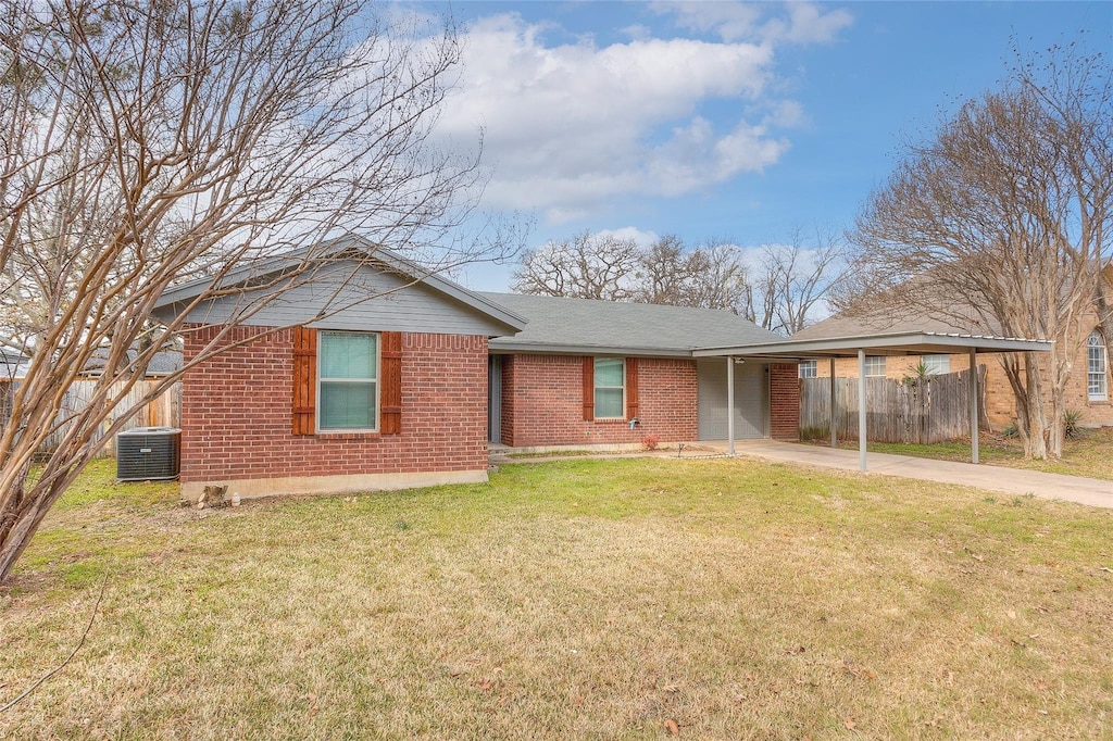 ranch-style house featuring a front lawn, a carport, and central air condition unit