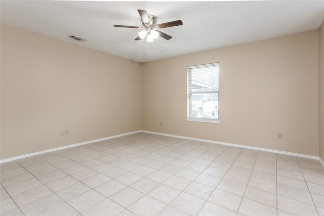 empty room with ceiling fan and light tile patterned flooring