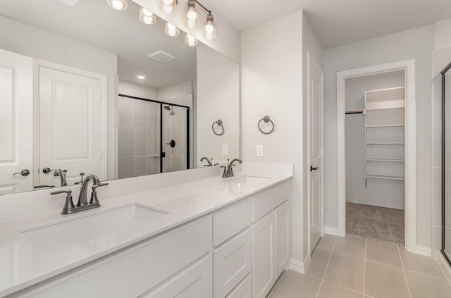 bathroom with tile patterned flooring, vanity, and a shower with shower door