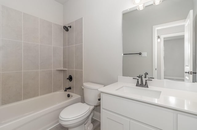 full bathroom featuring hardwood / wood-style floors, tiled shower / bath combo, toilet, and vanity