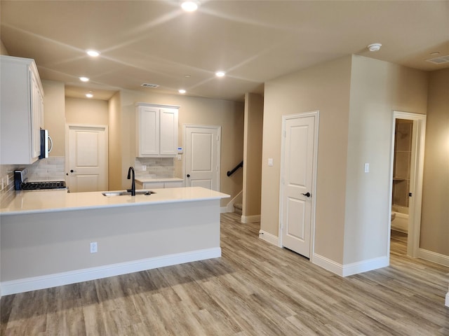 kitchen featuring white cabinets, stove, sink, and tasteful backsplash