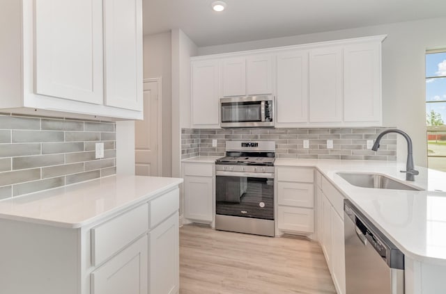 kitchen with white cabinetry, sink, and stainless steel appliances