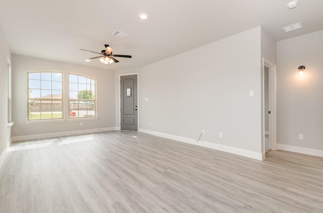 empty room with ceiling fan and light hardwood / wood-style flooring