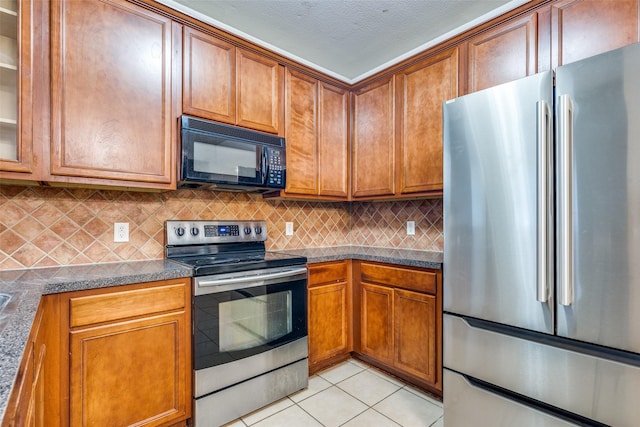 kitchen with decorative backsplash, light tile patterned floors, and appliances with stainless steel finishes