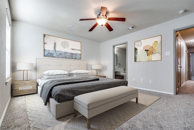 bedroom with ceiling fan, ensuite bathroom, and light carpet