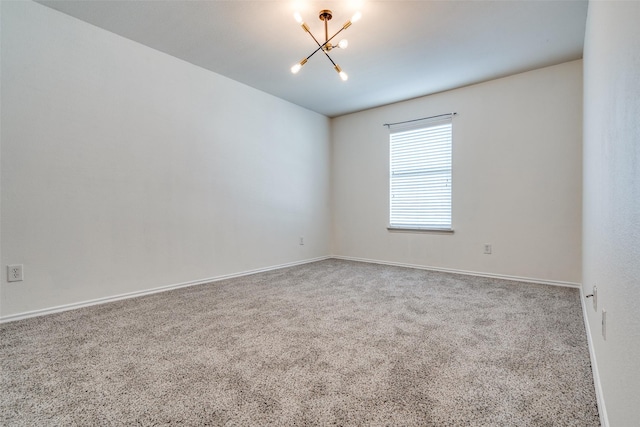 carpeted spare room featuring a notable chandelier