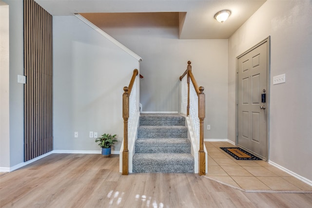 entryway with crown molding and light hardwood / wood-style floors