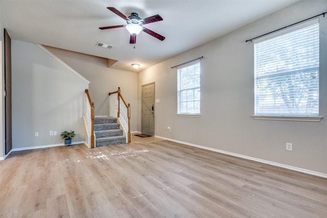 unfurnished living room with light wood-type flooring and ceiling fan