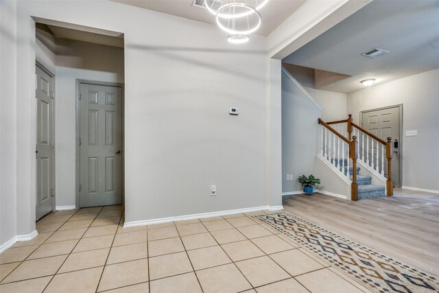 foyer featuring light tile patterned floors and an inviting chandelier