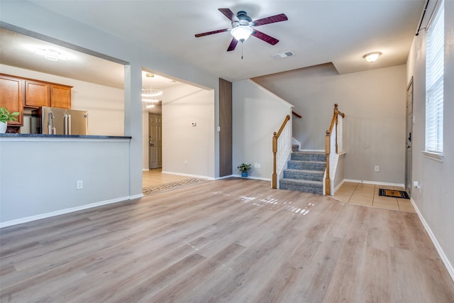 unfurnished living room featuring ceiling fan and light hardwood / wood-style floors