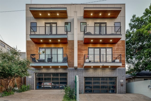 view of front of property featuring a garage, driveway, a balcony, and stucco siding