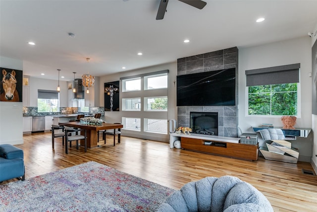 living room with light hardwood / wood-style flooring, ceiling fan, and a healthy amount of sunlight