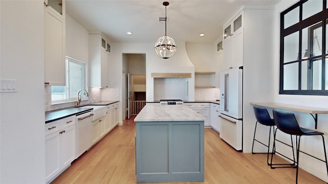 kitchen with pendant lighting, white appliances, decorative backsplash, and white cabinets