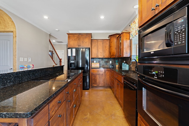 kitchen with decorative backsplash, dark stone counters, ornamental molding, sink, and black appliances