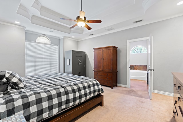 bedroom featuring light colored carpet, a raised ceiling, ceiling fan, crown molding, and connected bathroom