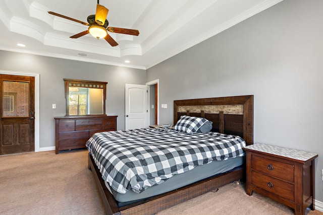 carpeted bedroom with ceiling fan, crown molding, and a tray ceiling