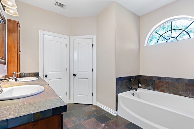 bathroom with a washtub and vanity