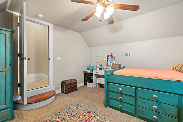 carpeted bedroom featuring ceiling fan, a textured ceiling, and vaulted ceiling