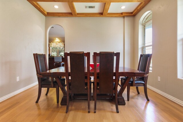 dining area with beamed ceiling, light hardwood / wood-style floors, and coffered ceiling