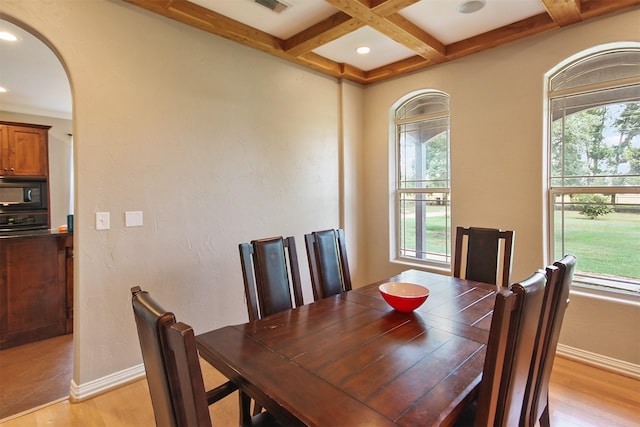 dining space featuring beam ceiling, light hardwood / wood-style floors, and coffered ceiling