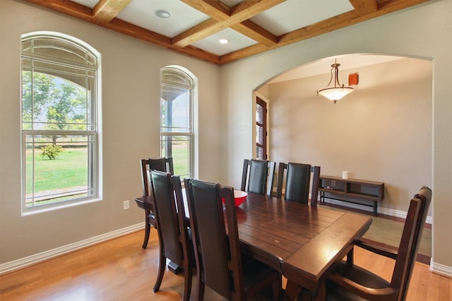 dining area featuring coffered ceiling, beam ceiling, and light wood-type flooring