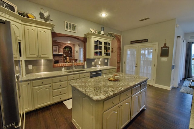 kitchen with sink, a center island, french doors, backsplash, and appliances with stainless steel finishes