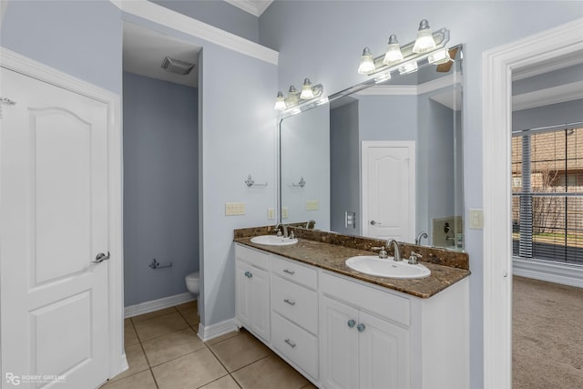 bathroom featuring tile patterned flooring, vanity, crown molding, and toilet