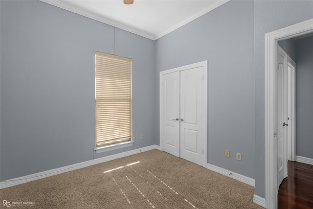 unfurnished bedroom featuring ornamental molding, dark carpet, and a closet