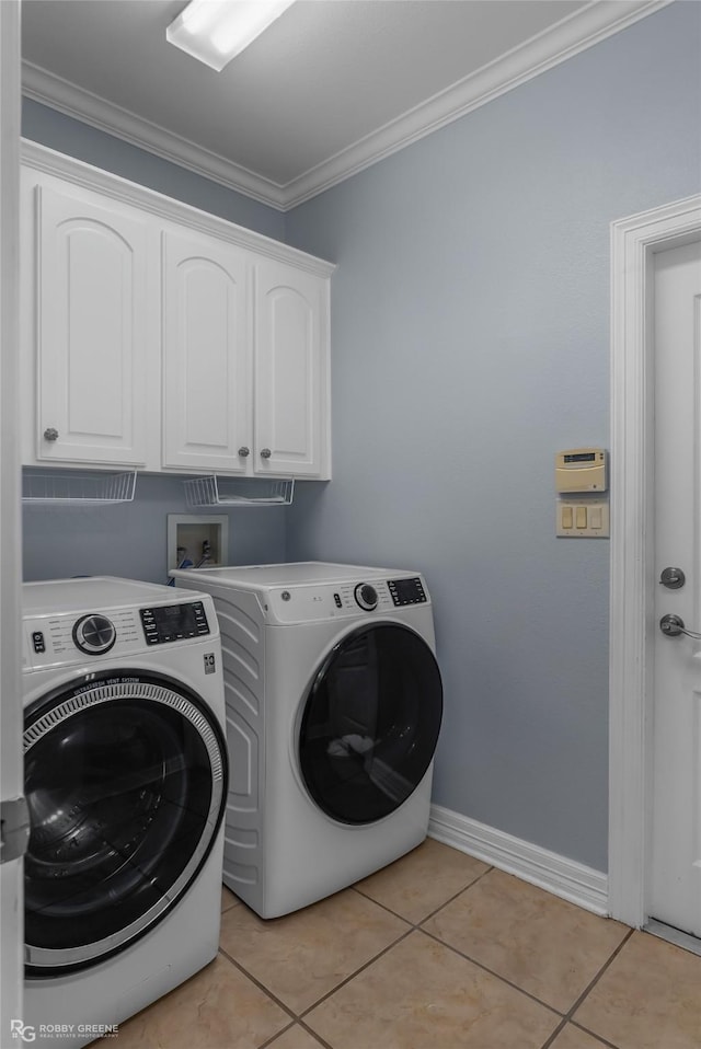 laundry area with cabinets, washing machine and dryer, ornamental molding, and light tile patterned flooring