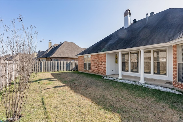 rear view of house featuring a yard