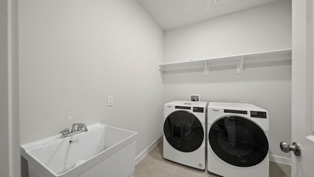 laundry area featuring sink, light tile patterned floors, and independent washer and dryer