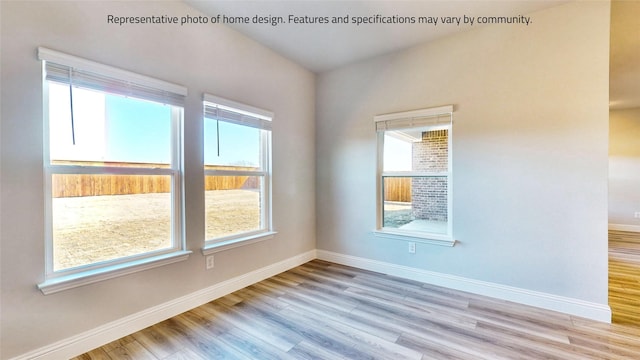 spare room featuring a wealth of natural light and light wood-type flooring