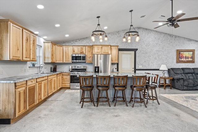 kitchen featuring a center island, sink, vaulted ceiling, light stone countertops, and stainless steel appliances