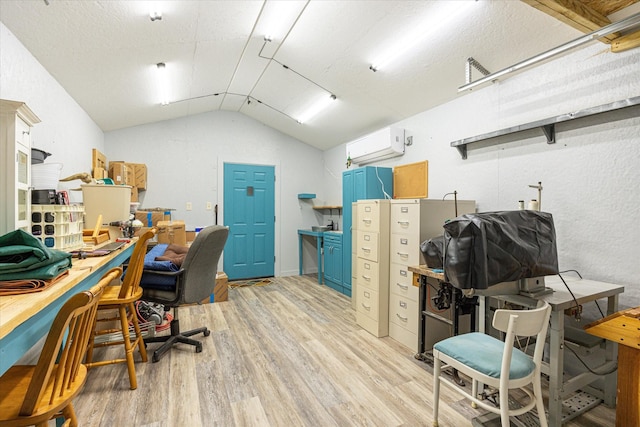 office with a wall mounted air conditioner, lofted ceiling, a textured ceiling, and light hardwood / wood-style flooring