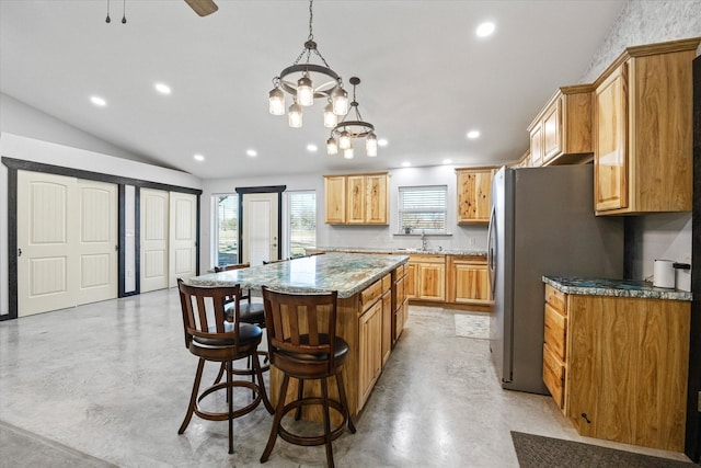 kitchen with a kitchen breakfast bar, light stone counters, vaulted ceiling, decorative light fixtures, and a center island