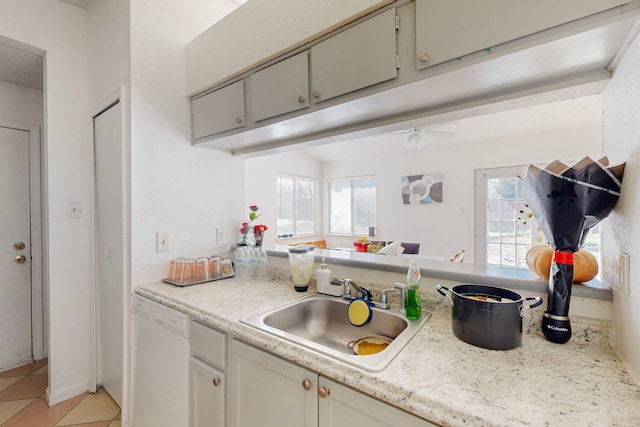 kitchen featuring white dishwasher, ceiling fan, light tile patterned floors, and sink